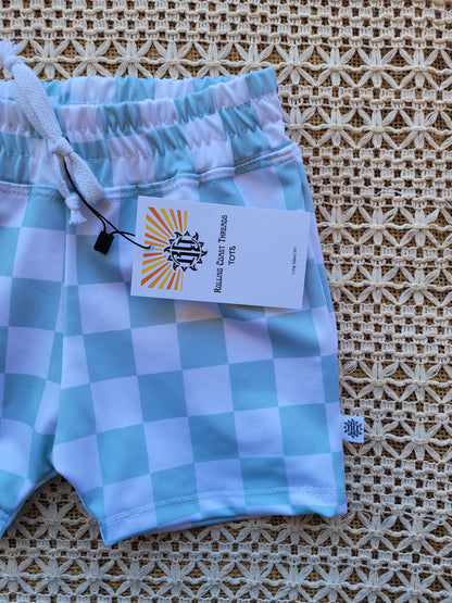 Close up of boys white and mint green checkered swim shorts