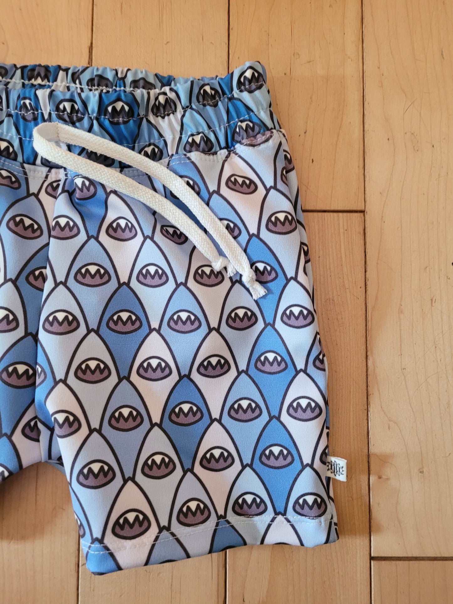 Close up of Boys shark bite blue and grey colored swim shorts