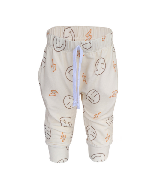 Front of Smiley Sweatpants. Organic cream colored sweatpants with orange lightening bolts and outlined smiley faces.