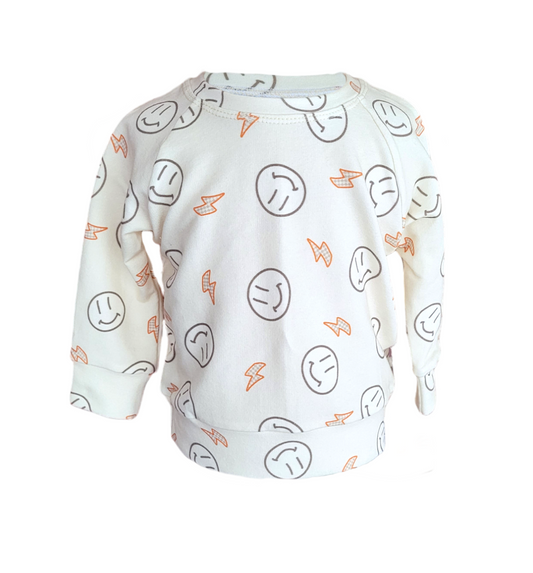 Front of Smiley Sweatshirt. Organic Cream sweatshirt with orange lightening bolts and outlined smiley faces.