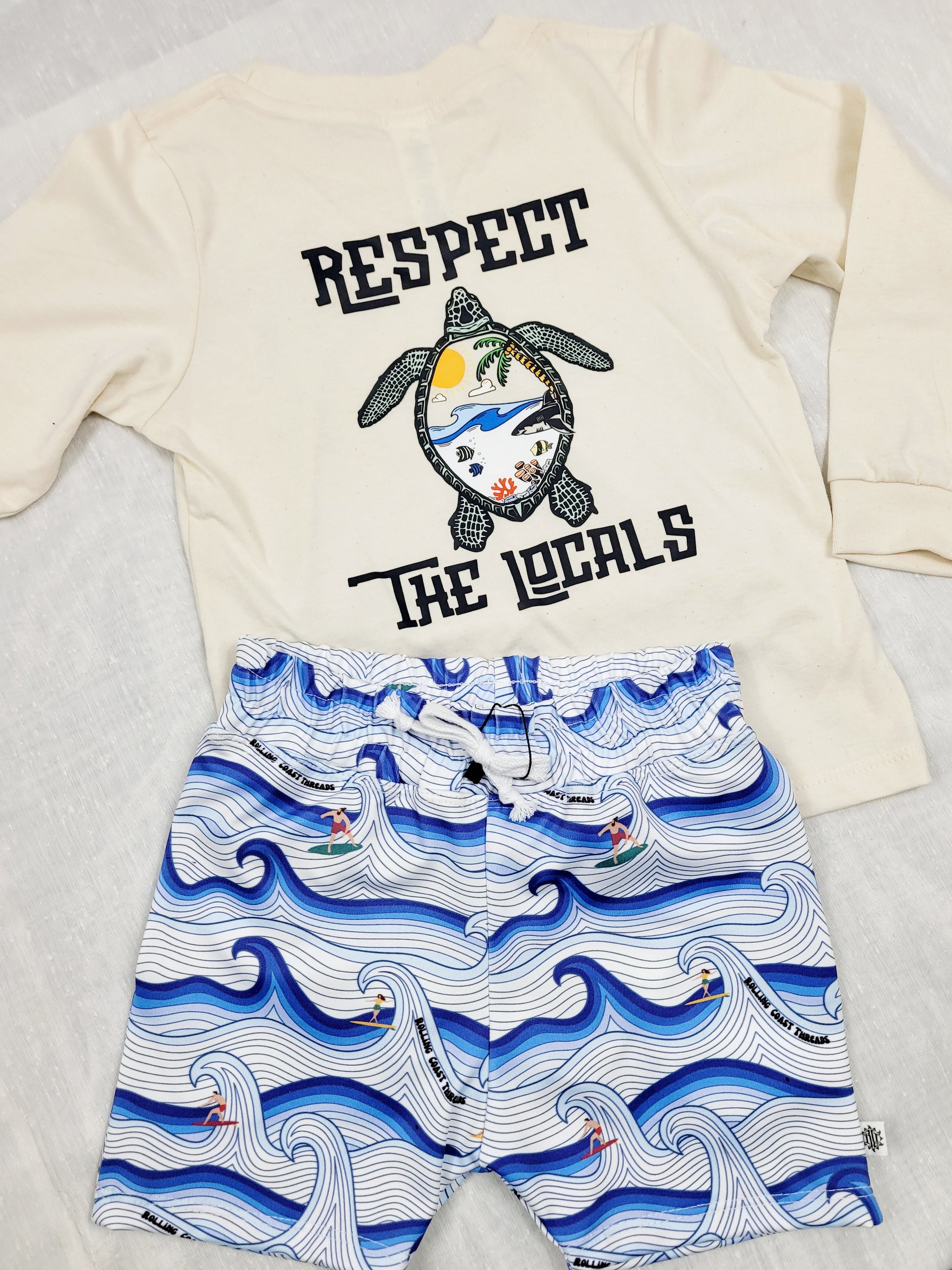 Boys swim shorts. White and blue waves with surfers matched with turtle shirt