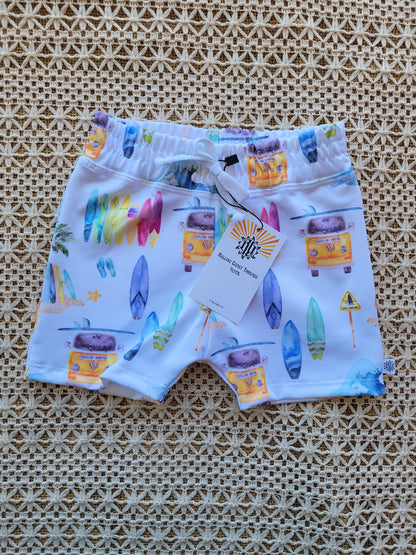 Front of Boys white swim shorts with colorful surfboards