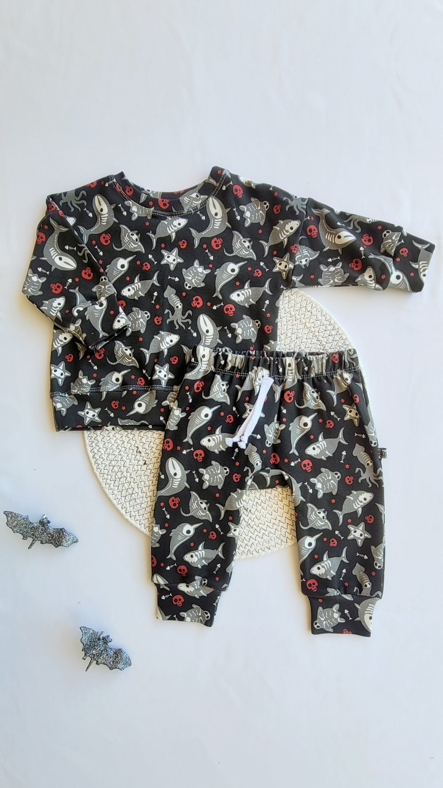 Kids Halloween outfit set – skeleton shark sweatshirt and joggers in organic cotton French terry, spooky sea print, flat lay with bats