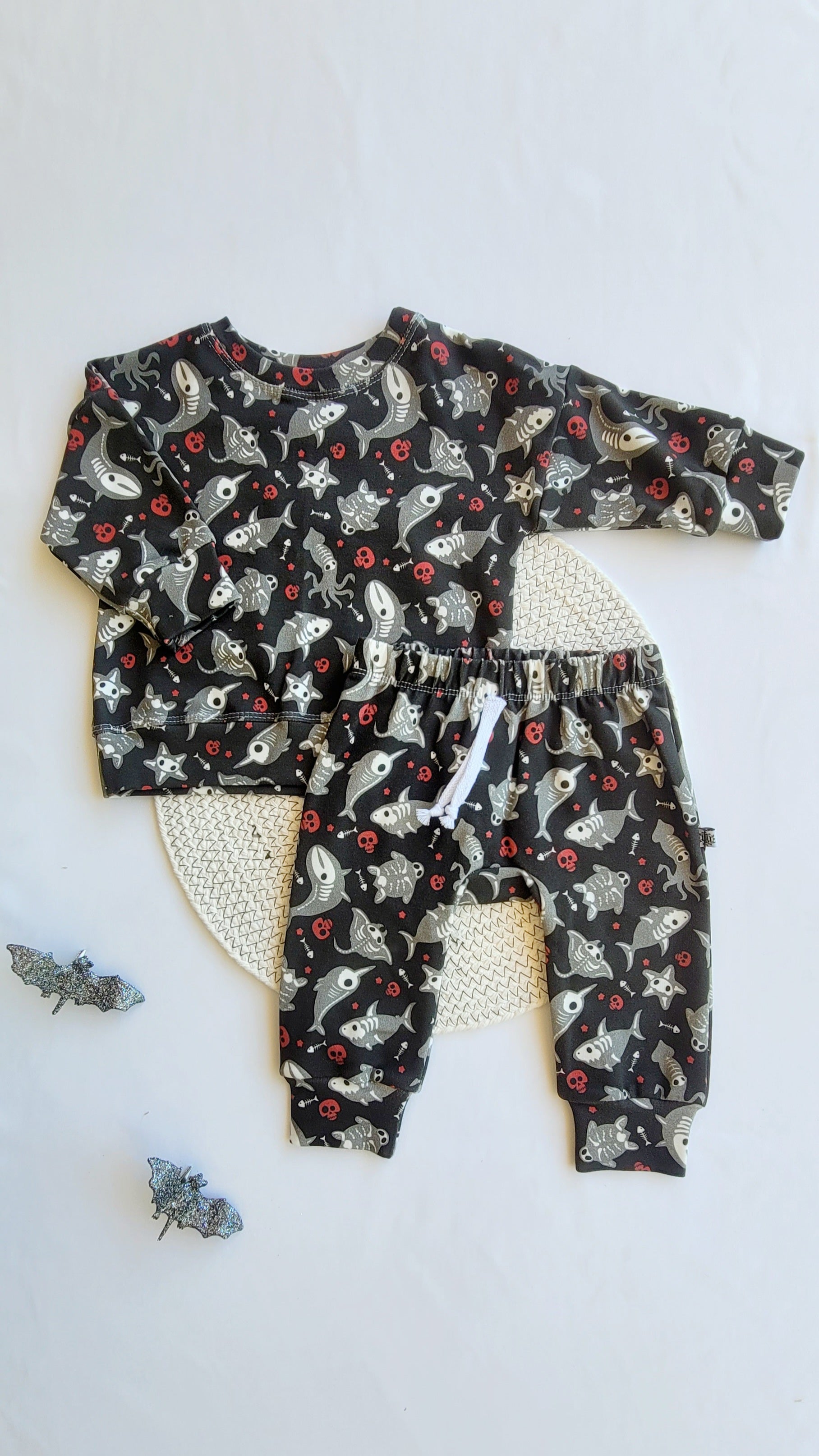 Kids Halloween outfit set – skeleton shark sweatshirt and joggers in organic cotton French terry, spooky sea print, flat lay with bats