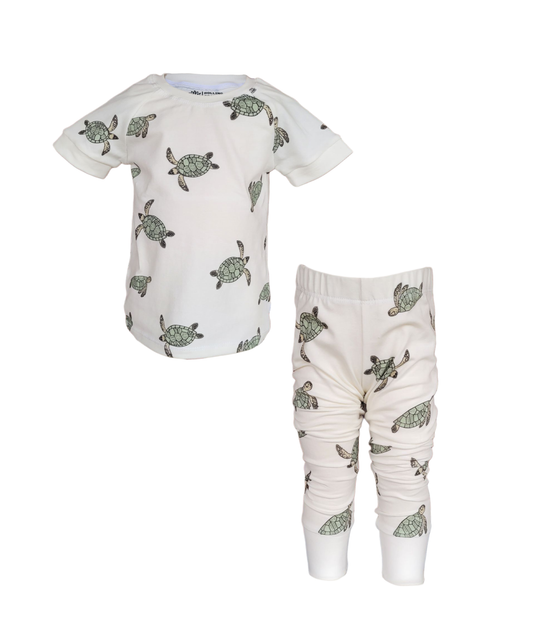 Kids organic cotton pajama set with green sea turtle print – short sleeve top and long pants in soft cream color, unisex eco-friendly sleepwear