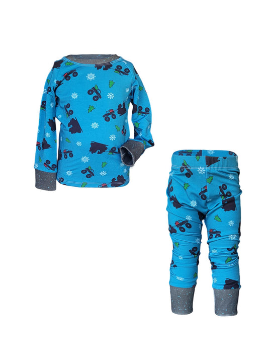 Kids holiday pajama set with Santa sleigh silhouette made of monster trucks, snowflakes, and trees in blue on bamboo french terry